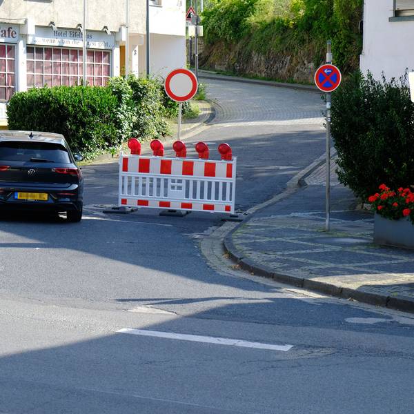In Heimbach ist die Mariawalder Straße wegen Bauarbeiten abgesperrt. Ein VW Golf mit niederländischen Kennzeichen fährt an der Absperrung vorbei.