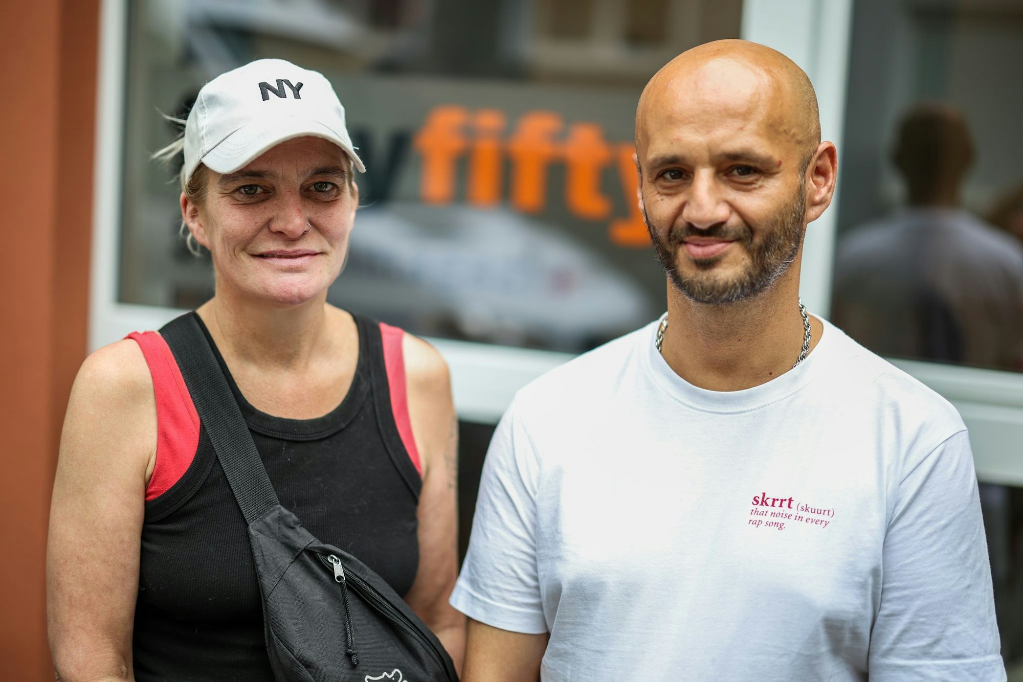 Der ehemalige Obdachlose Pino steht mit einer Bekannten vor der Düsseldorf Beratungsstelle FiftyFifty.