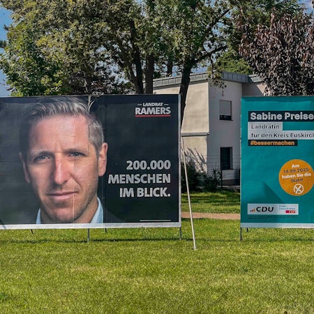 Das Bild zeigt Wahlplakate von Landrat Markus Ramers und Herausforderin Sabine Preiser-Marian.