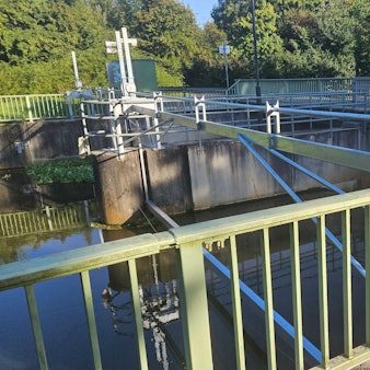 Ein Metallbauer arbeitet an einer Konstruktion an einem Wehr in der Erft.