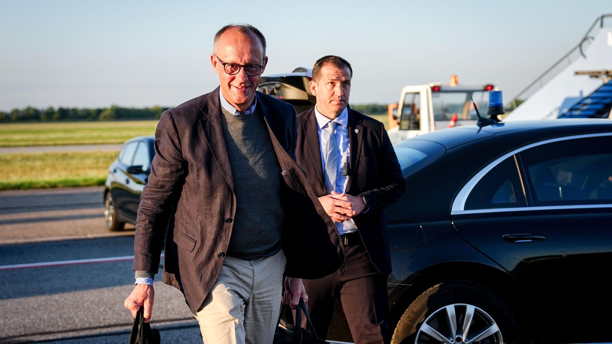Bundeskanzler Friedrich Merz (CDU,l) geht auf dem Franz-Josef-Strauß-Flughafen zum Airbus A319 der Luftwaffe für den Flug nach Washington.