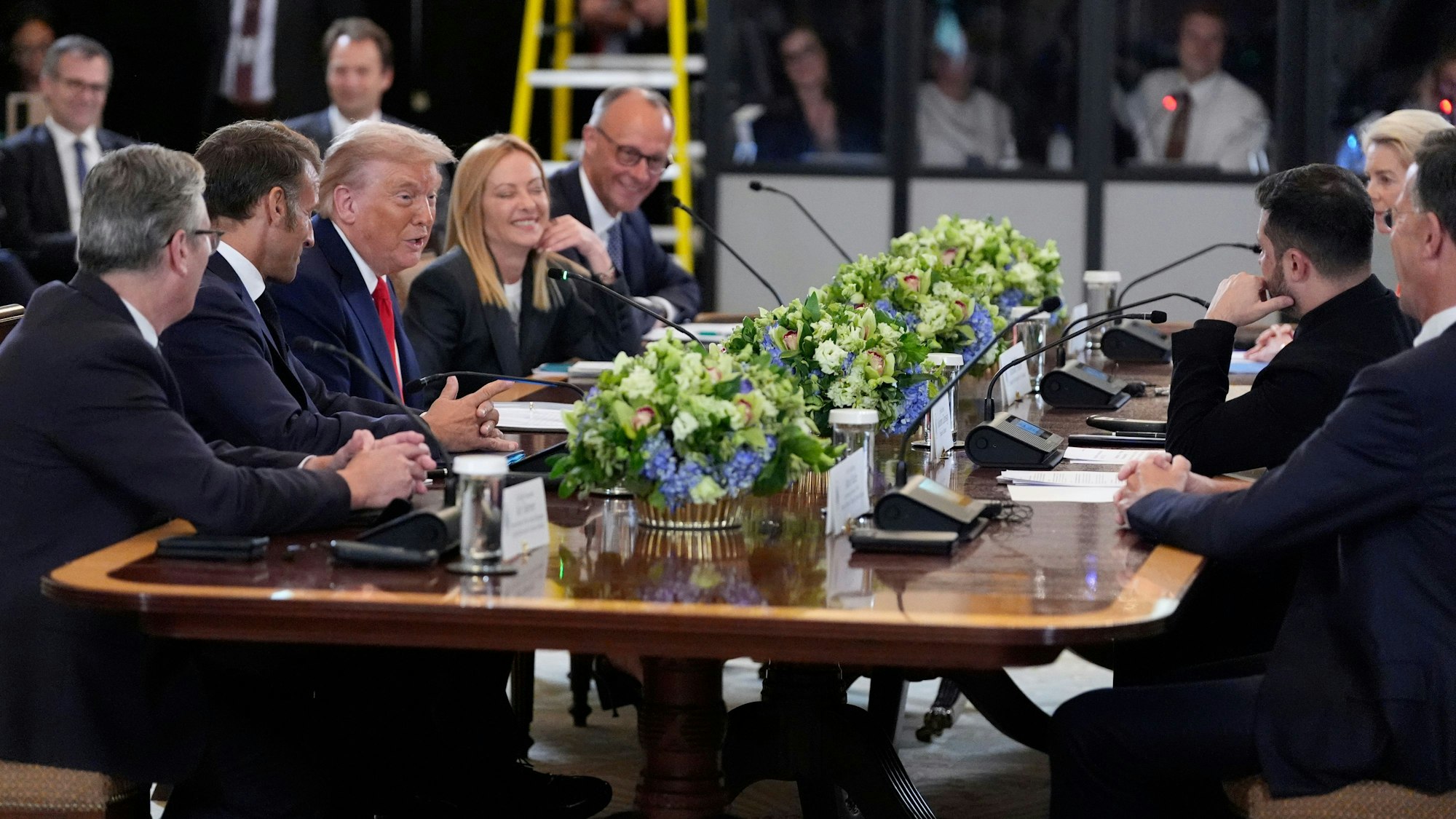 18.08.2025, USA, Washington: US-Präsident Donald Trump (Mitte-links) spricht während eines Treffens mit Wolodymyr Selenskyj, Präsident der Ukraine (Mitte rechts) und europäischen Staatsoberhäuptern im Weißen Haus während der britische Premierminister Keir Starmer (l-r) Frankreichs Präsident Emmanuel Macron, Italiens Premierministerin Giorgia Meloni und Bundeskanzler Friedrich Merz (CDU) zuhören. Foto: Alex Brandon/AP/dpa +++ dpa-Bildfunk +++