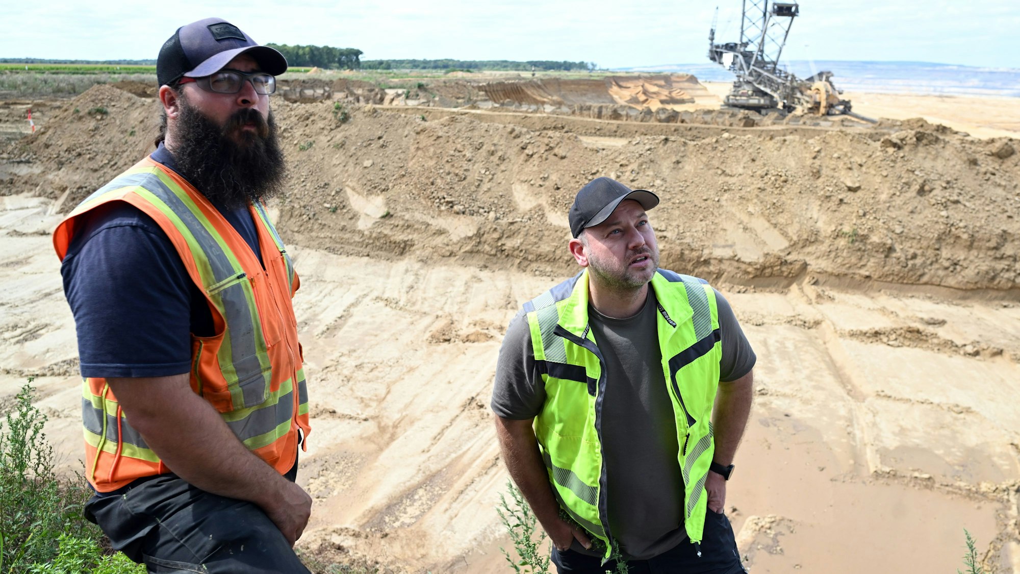 Das Foto zeigt zwei Männer vor dem Tagebau.