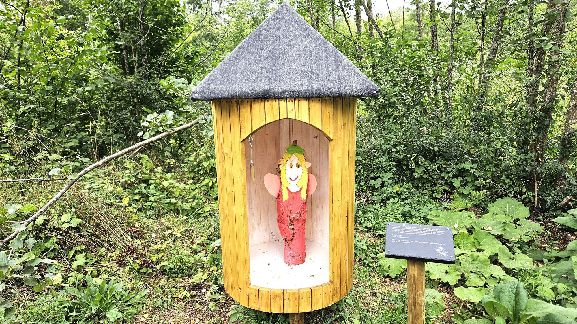 Im Zauberwald in Urft steht eine Holzfigur in einem Holzhäuschen.