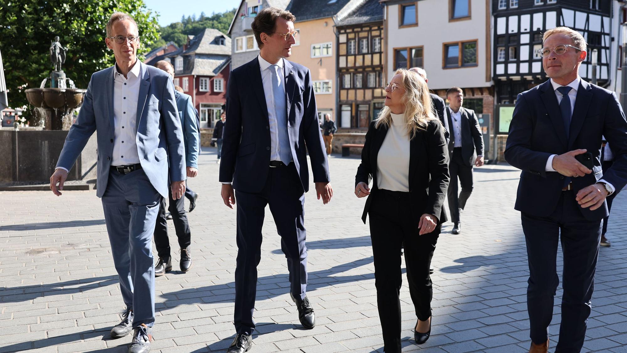 Das Bild zeigt, wie die Bürgermeisterin beim Rundgang durch Bad Münstereifel von NRW-Ministerpräsident Hendrik Wüst (2.v.l.), Detlef Seif (v.l.) und Staatssekretär Daniel Sieveke begleitet wird.