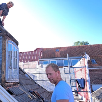 Das Foto zeigt zwei Arbeiter auf dem Dach des Wipperfürther Rathauses