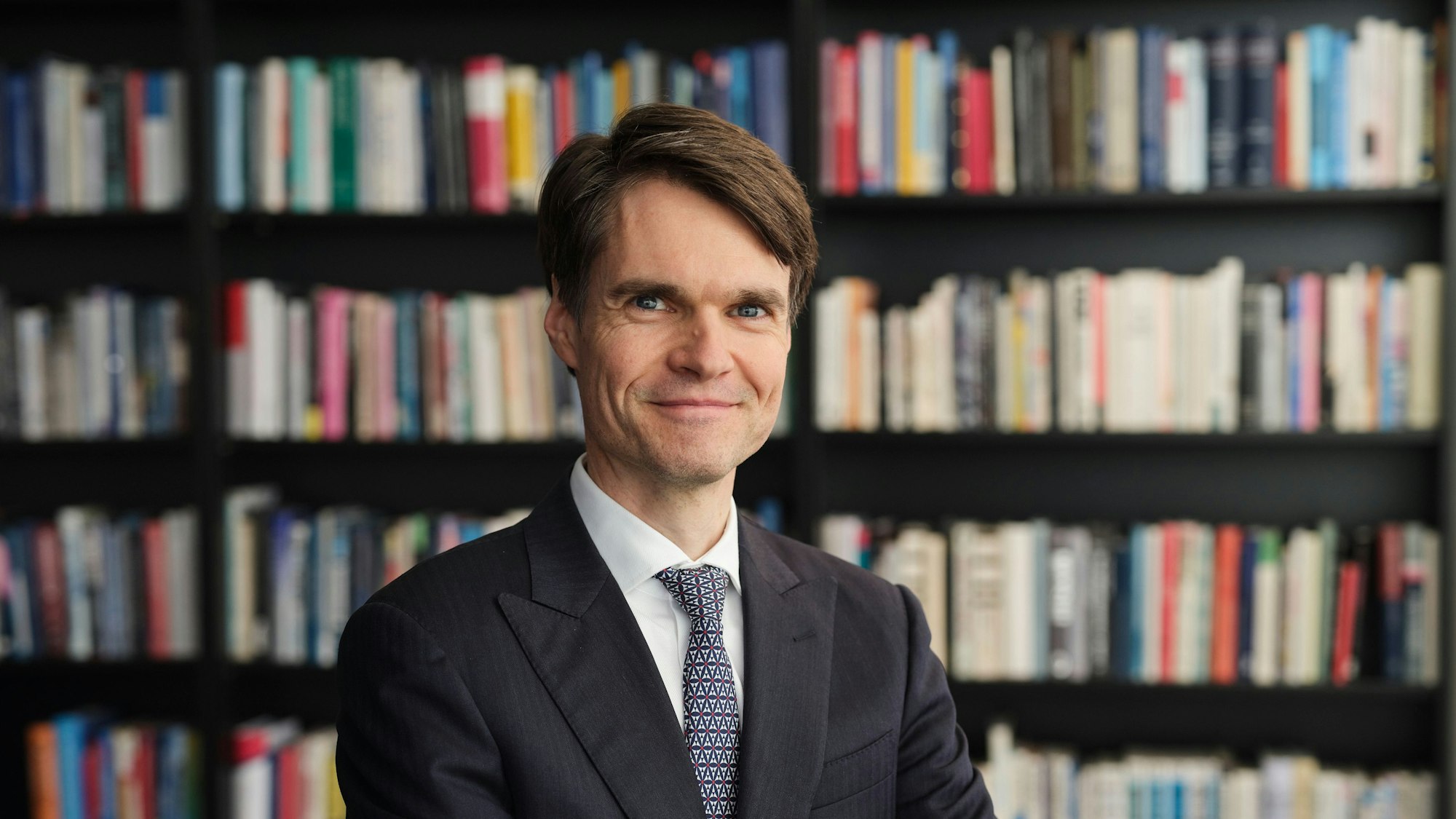 Sven Ebert, Wissenschaftler bei Flossbach von Storch, ist im Porträt vor einer Bücherwand zu sehen.