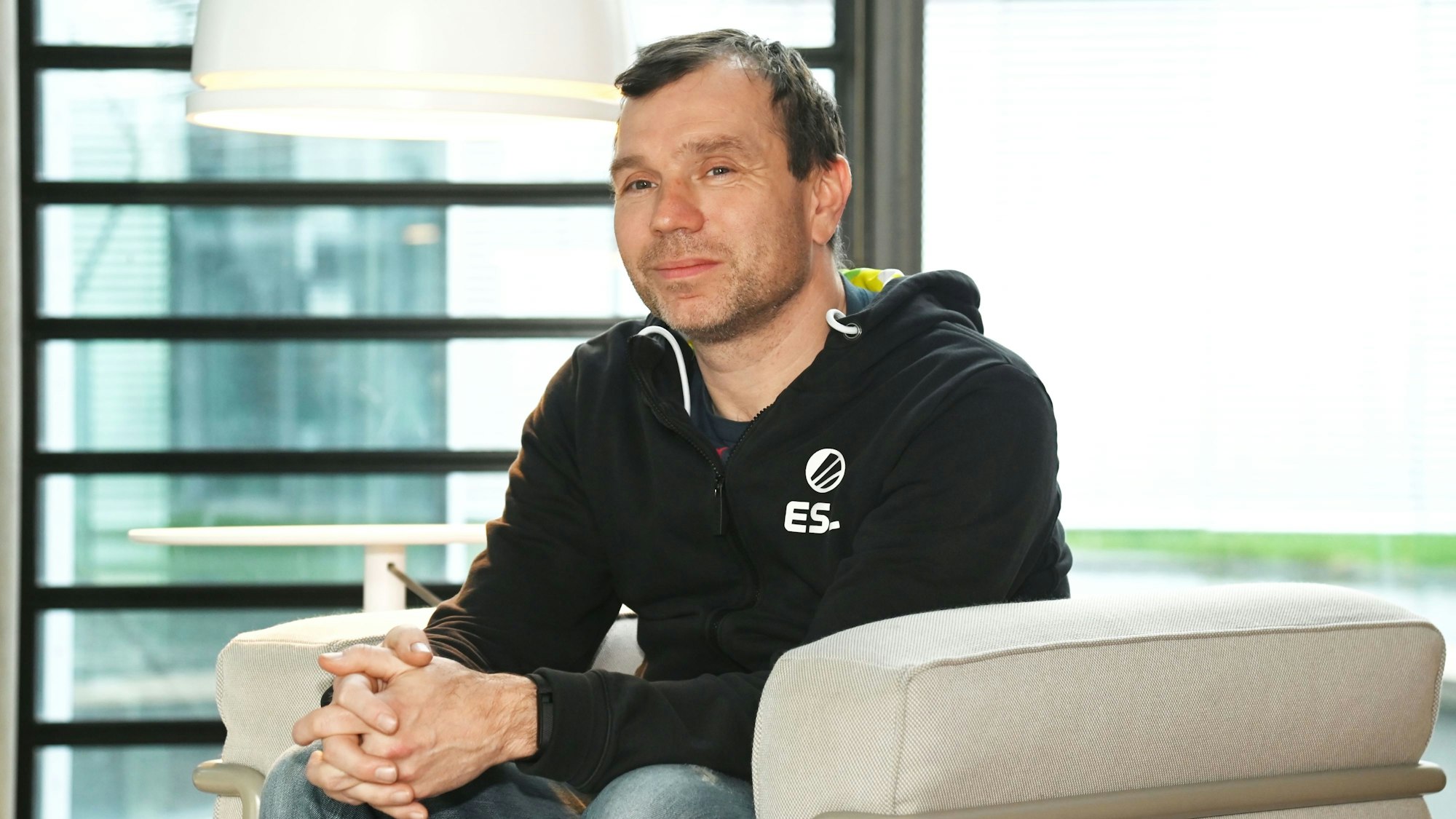 Ralf Reichert sitzt auf einem hellen Sessel