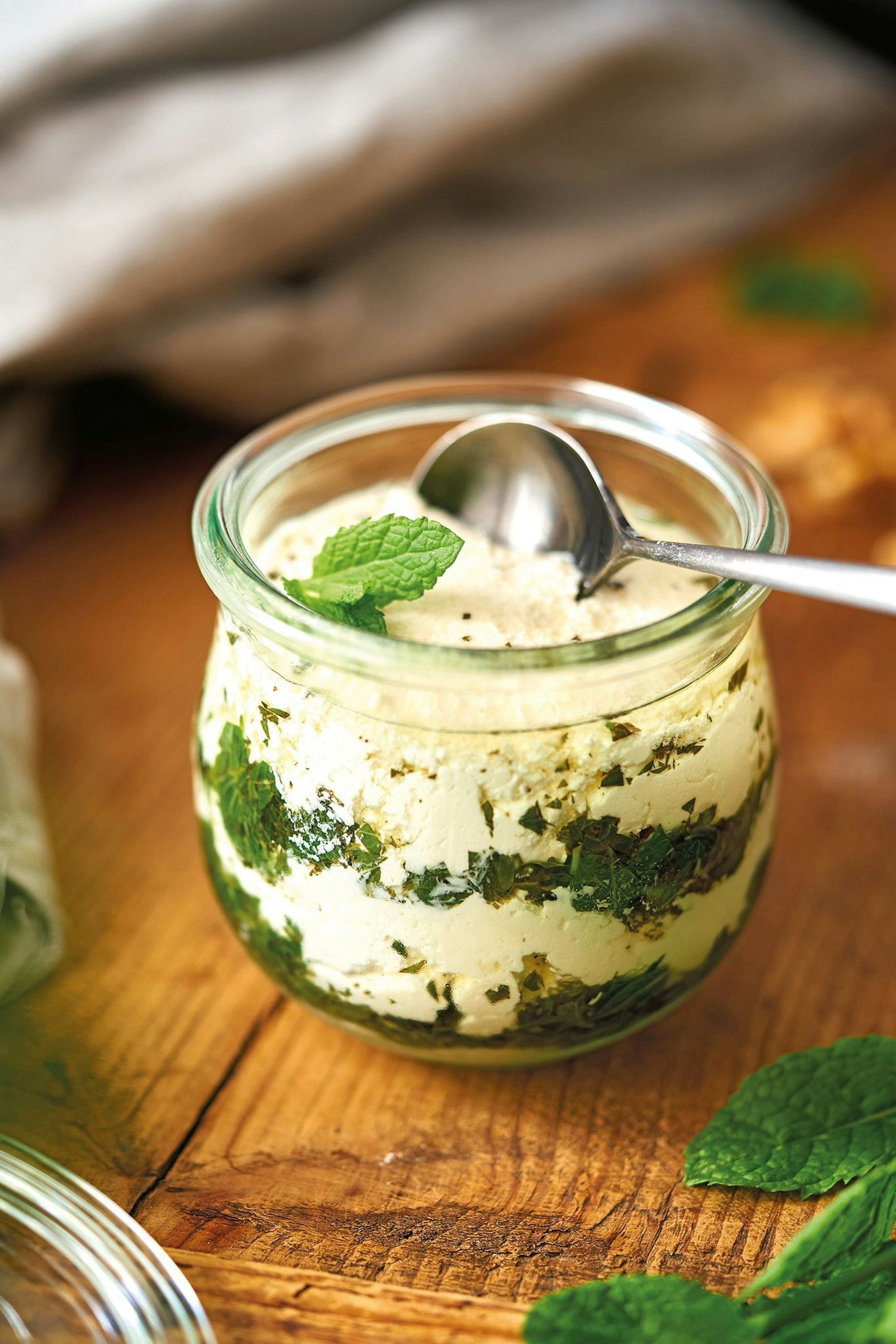 So wird selbst gemachter Käse zum Hingucker: Den gut abgetropften Frischkäse cremig rühren und abwechselnd im Glas mit Kräutermasse schichten.