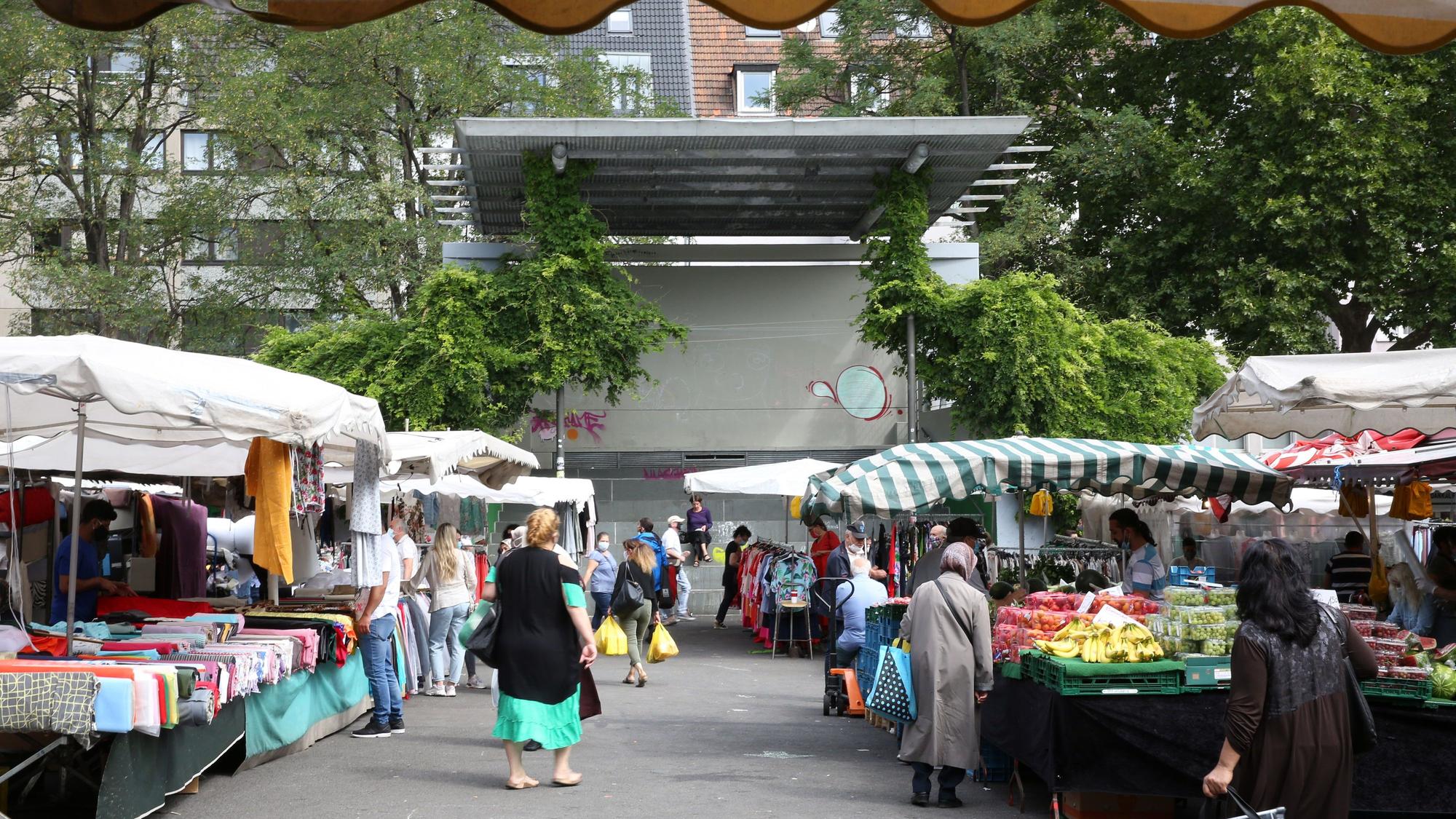 Auf einem Platz mit Freilicht-Tribüne sind Marktstände aufgebaut.