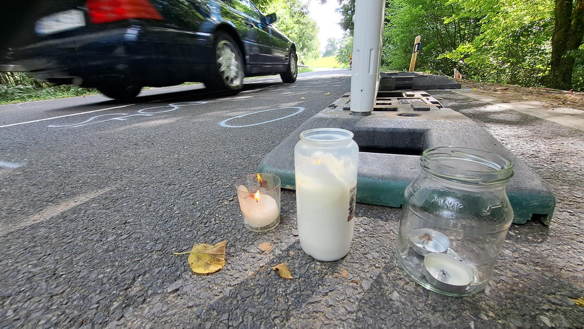 Zwischen Warnbaken stehen Kerzen auf der Dürschtalstraße, auf der sich am Samstag (16.8.) ein tödlicher Unfall ereignet hat, bei dem vier Teenager im Alter von 14 bis 19 Jahren ums Leben kamen.