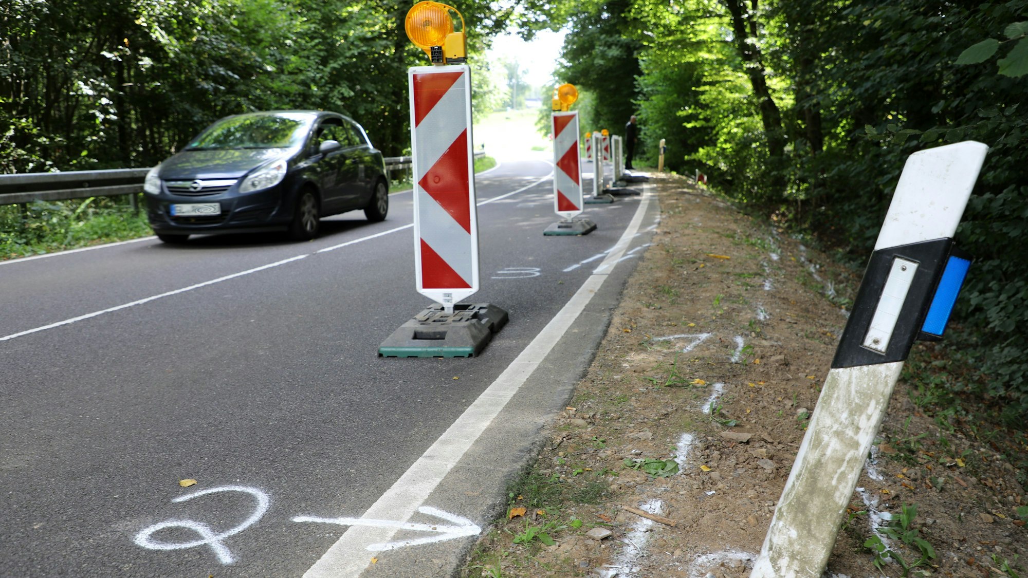 Auf einer Straße im Dürschtal bei Kürten-Dürscheid sind die Unfallspuren eines schweren Unfalls zu sehen, bei dem am Samstag (16.8.) vier junge Menschen ums Leben kamen. An der Unfallstelle fehlt auf der rechten Seite der Straße eine Leitplanke.