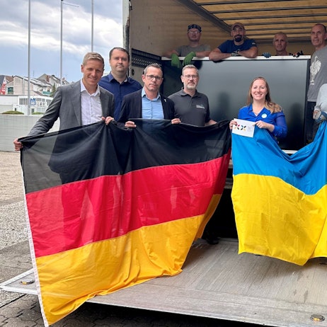 Eine Gruppe Menschen hält eine Deutschland- und eine Ukraineflagge. Zu ihnen gehören Landrat Markus Ramers und die Vertreterin des Vereins Blau-Gelbes Kreuz, Nadiia Khmeliuk.