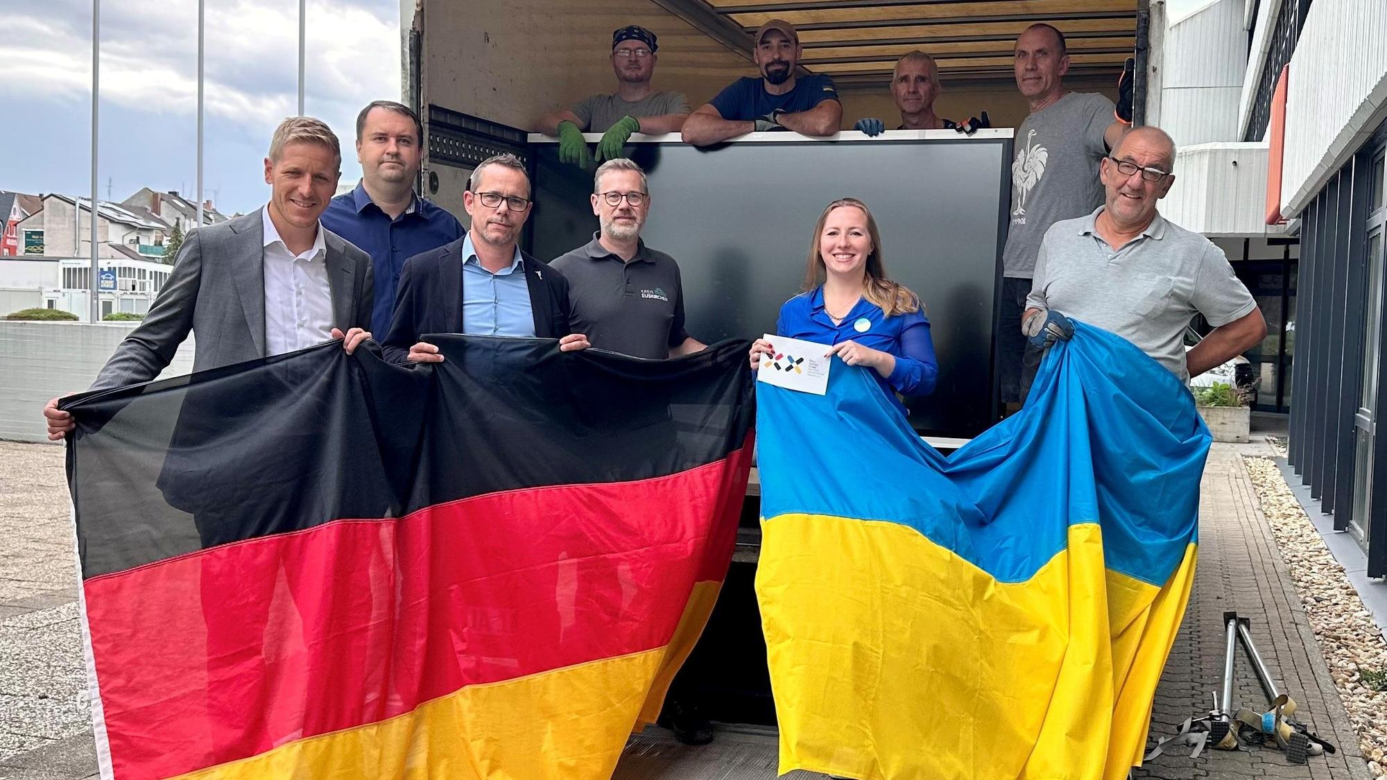 Eine Gruppe Menschen hält eine Deutschland- und eine Ukraineflagge. Zu ihnen gehören Landrat Markus Ramers und die Vertreterin des Vereins Blau-Gelbes Kreuz, Nadiia Khmeliuk.