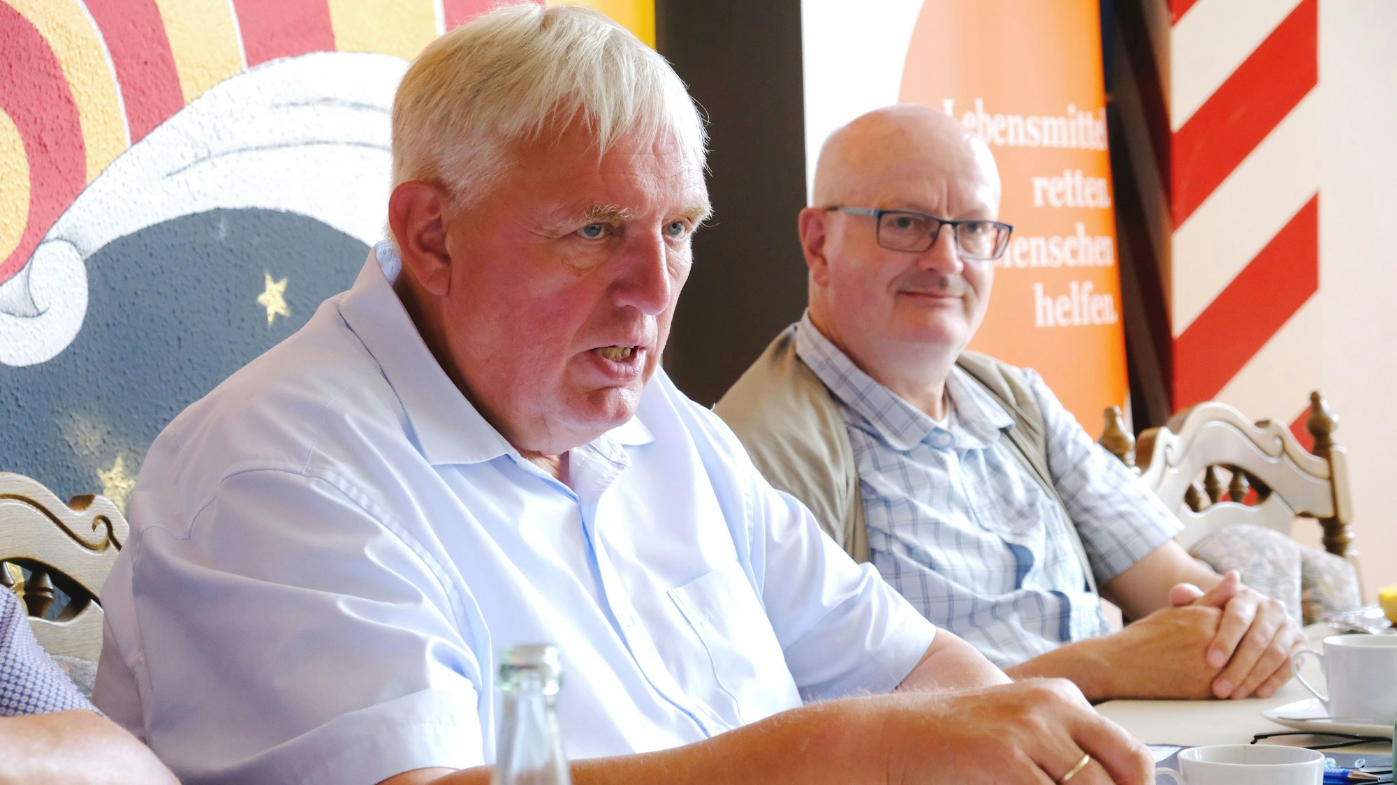 NRW-Arbeits- und Sozialminister Karl-Josef Laumann (CDU) beim Besuch der Mechernicher Tafel, er sitzt an einem Tisch neben Peter Vorsteher.