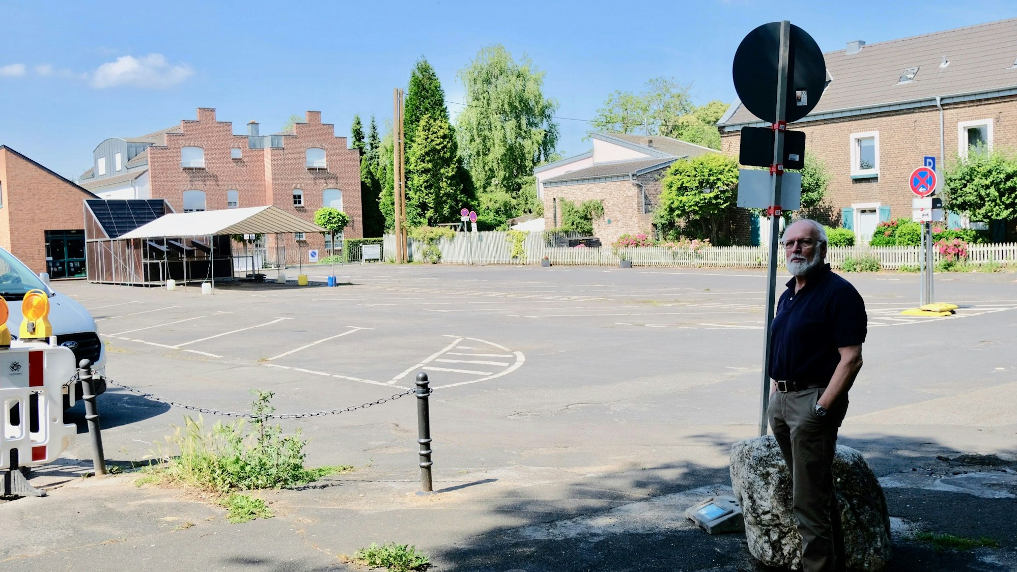 Ein Mann mit weißem Bart steht am Rand des Kirchplatzes in Lövenich.