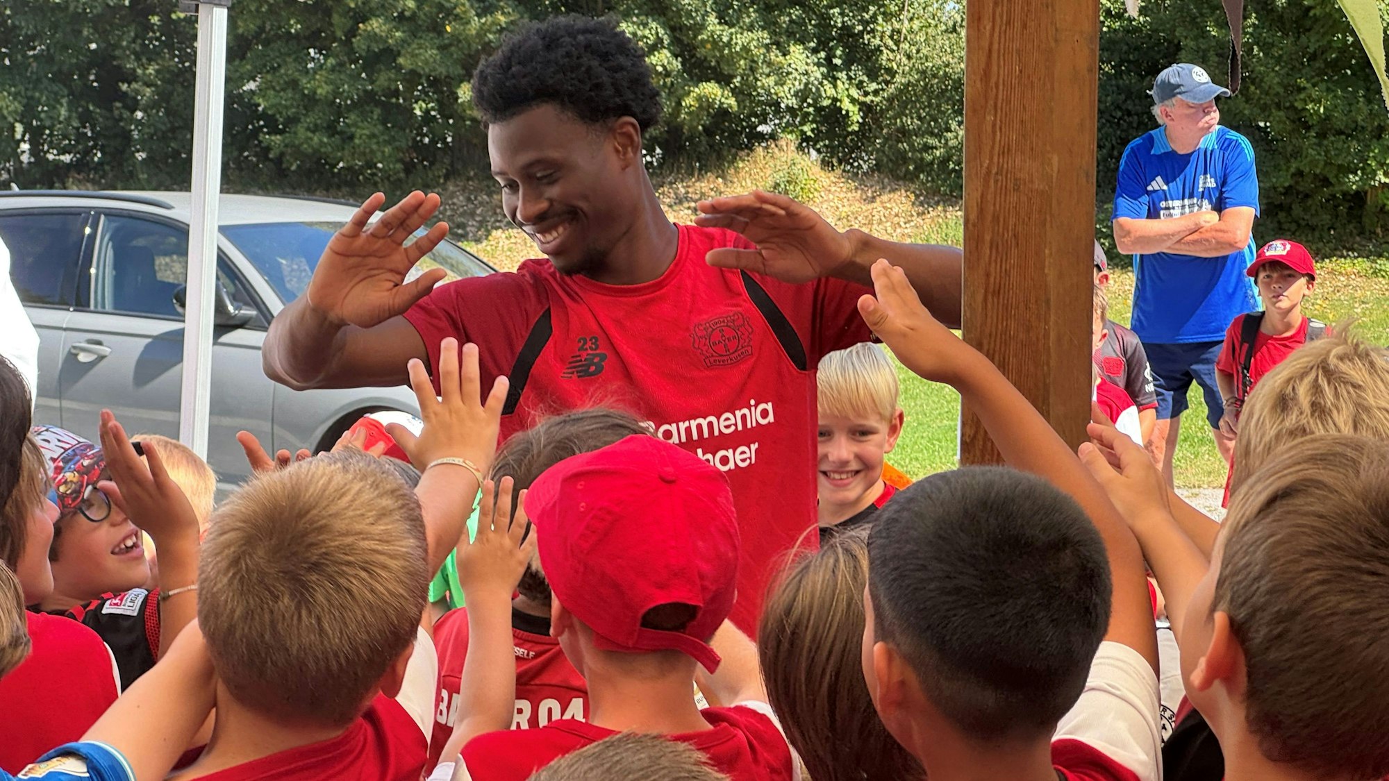 Nathan Tella grüßt die Kinder der Fußballschule. Der große Andrang scheint ihn nichts auszumachen.