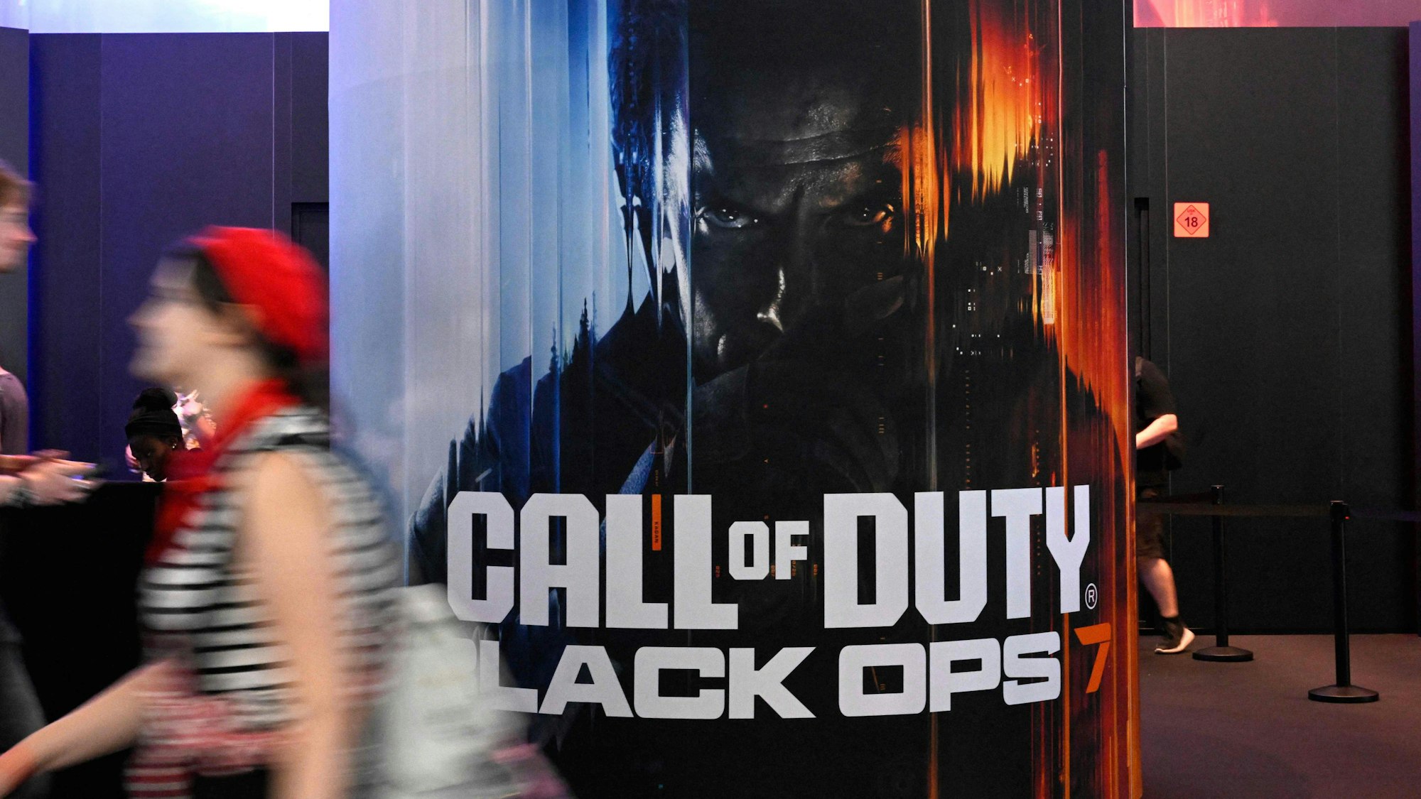 Bei der Gamescom geht ein Besucher an einem Plakat von Call of Duty vorbei.