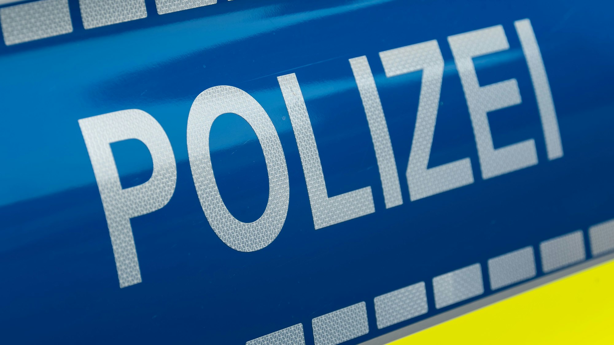 Der Schriftzug Polizei steht auf einem Fahrzeug der Polizei.