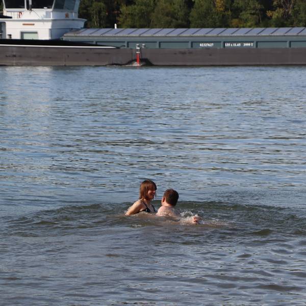 Das Bild zeigt zwei Personen im Rhein bei Wesseling.