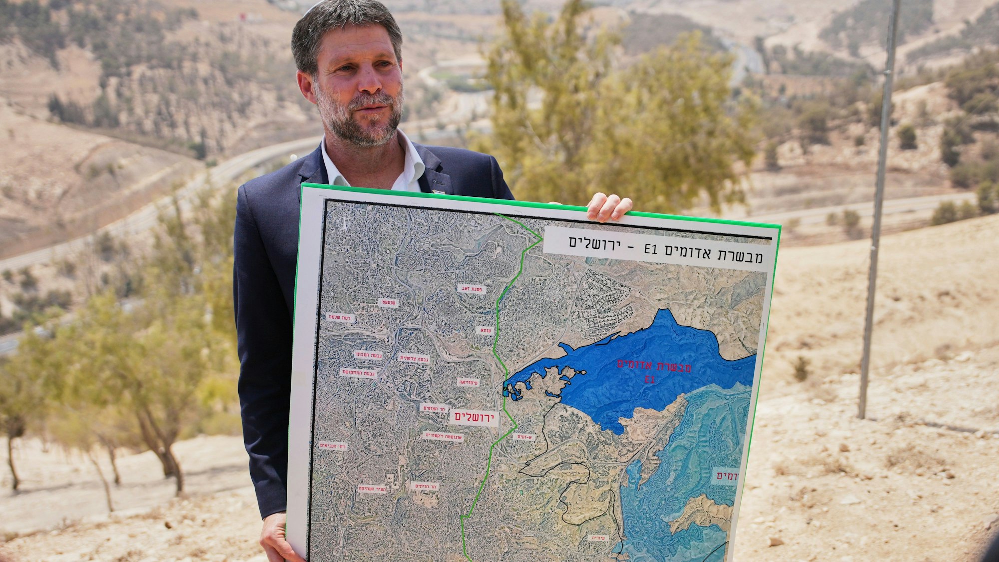 Der israelische Finanzminister Bezalel Smotrich hält während einer Pressekonferenz in der Nähe der Siedlung Maale Adumim im israelisch besetzten Westjordanland eine Karte, auf der das Siedlungsprojekt E1 dargestellt ist. (Archivbild)