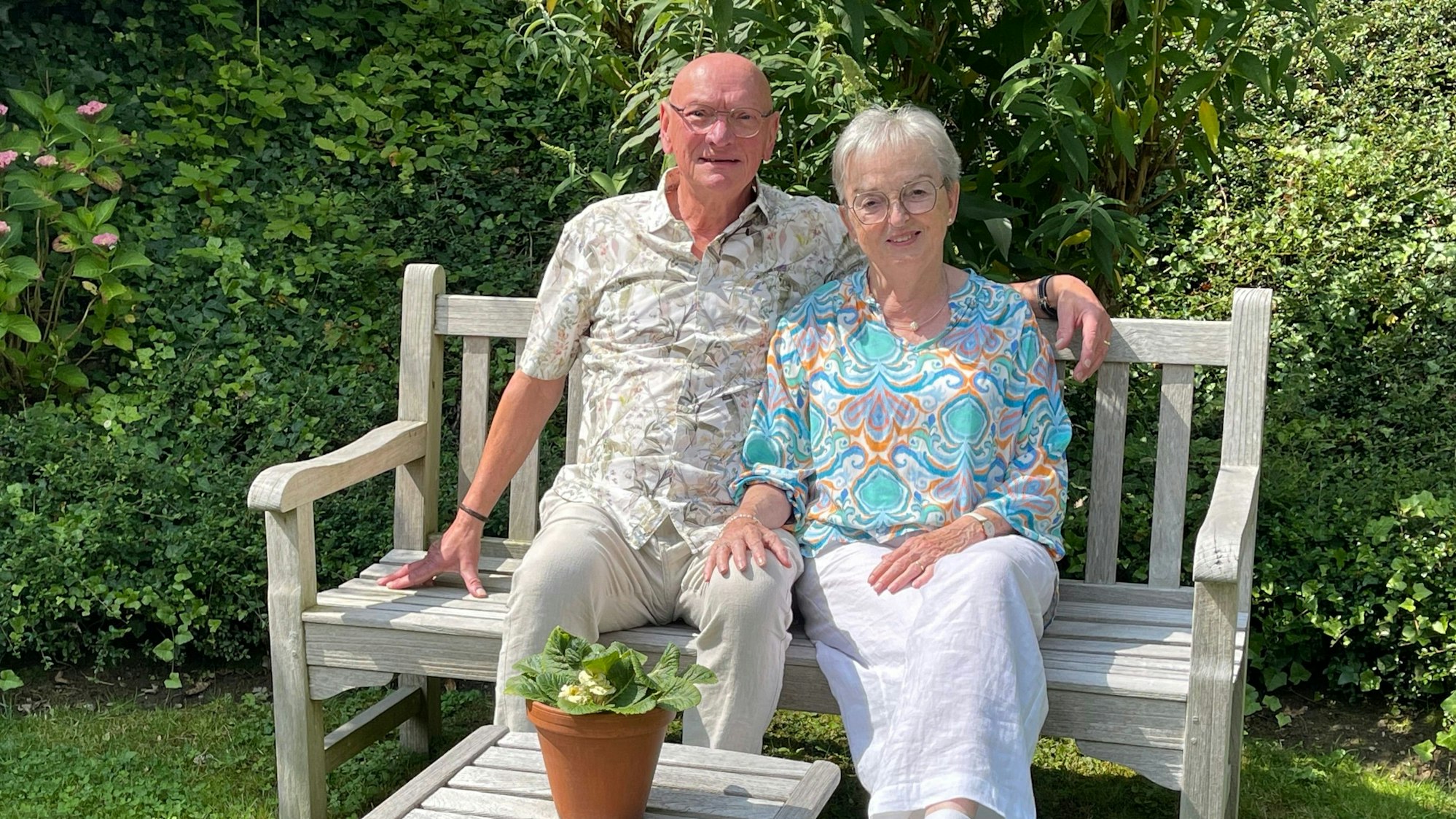 Das Foto zeigt das Ehepaar Hildburg und Joachim Ramke sitzend auf einer Gartenbank