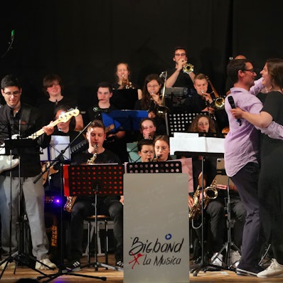 Das Bild zeigt die Big Band von La Musica, ihnen voran ein tanzendes Paar.