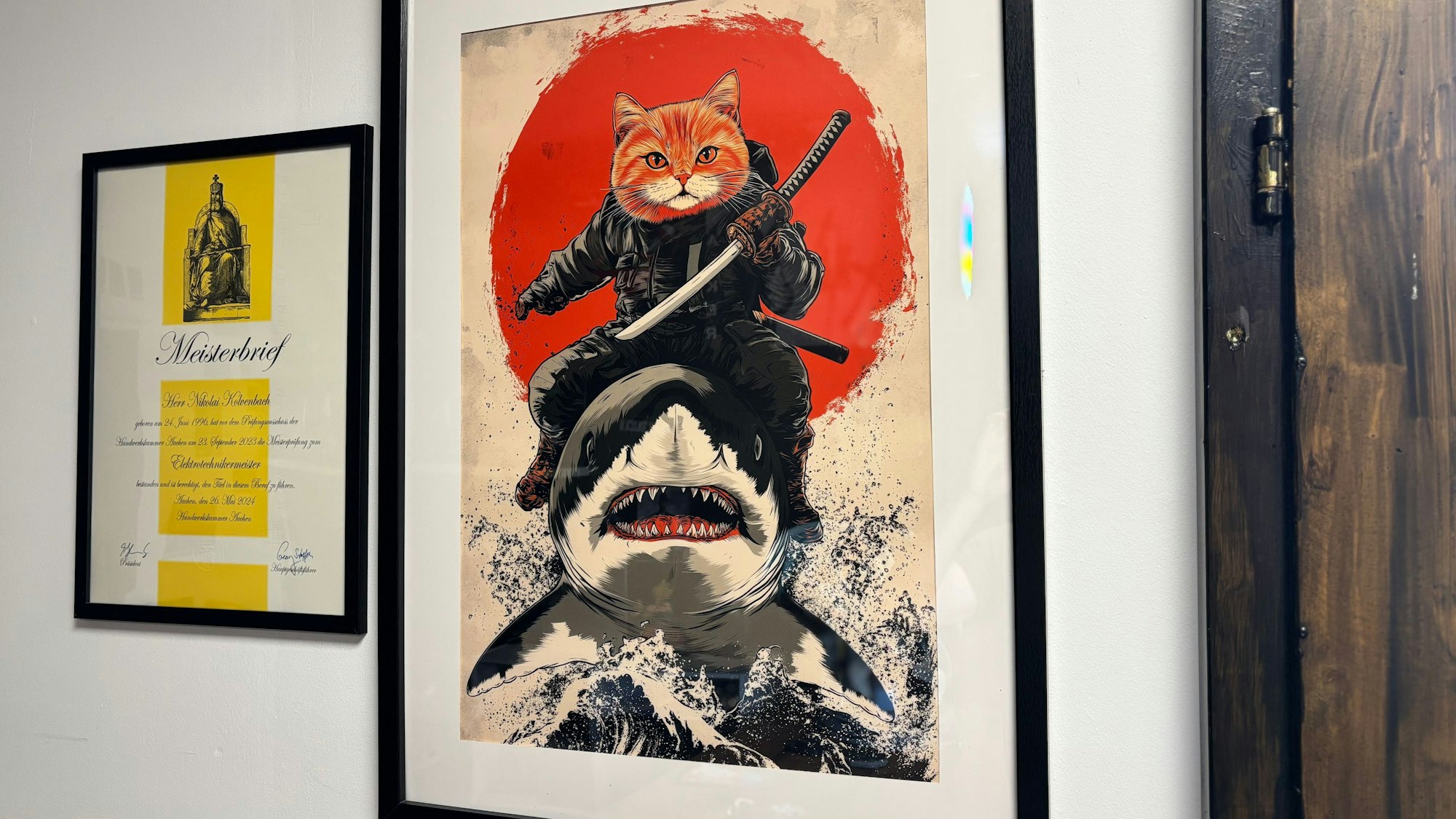 Das Bild zeigt ein Poster an der Wand. Daneben hängt ein Meisterbrief.