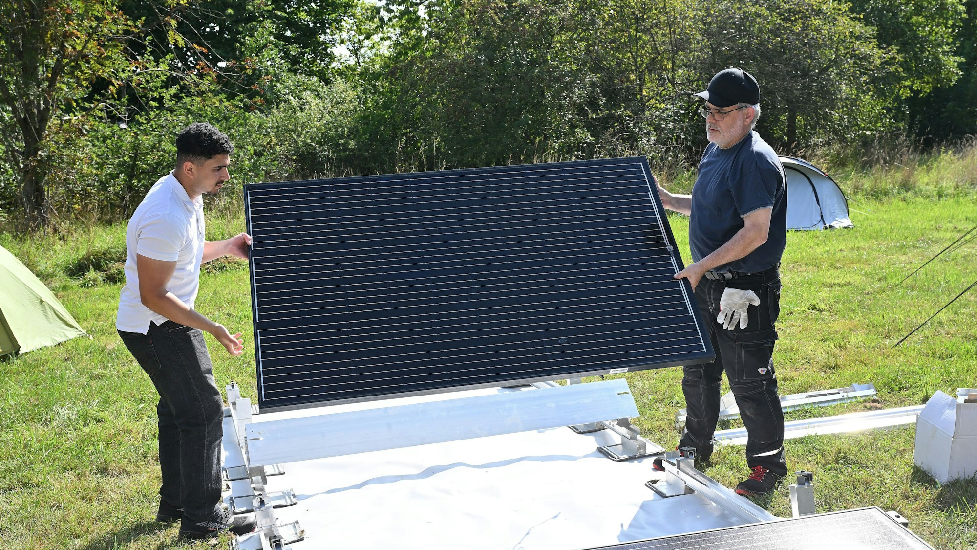 Zwei Männer tragen ein Modul.