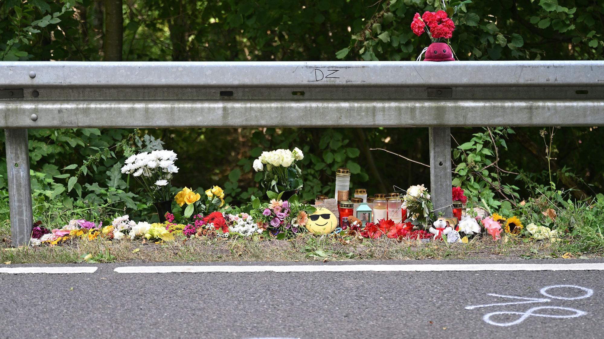 Auf beiden Seiten der Unfallstelle haben Menschen Blumen, Kerze und Kuscheltiere abgelegt.