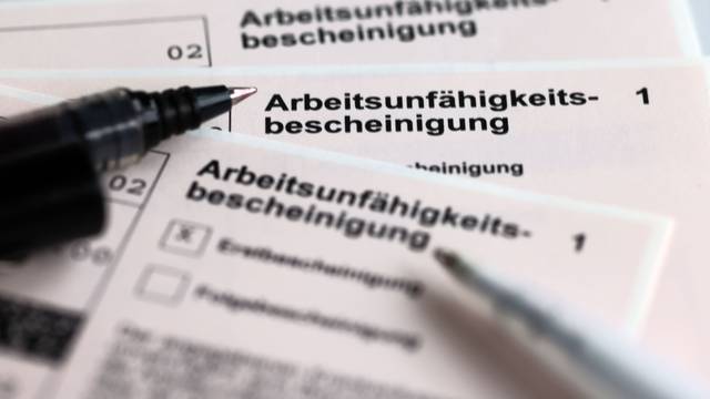 Arbeitsunfähigkeitsbescheinigung mit Kugelschreiber daneben.