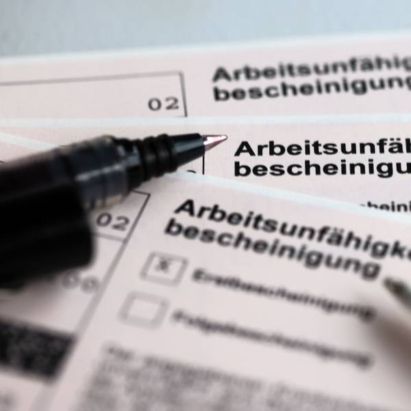 Arbeitsunfähigkeitsbescheinigung mit Kugelschreiber daneben.