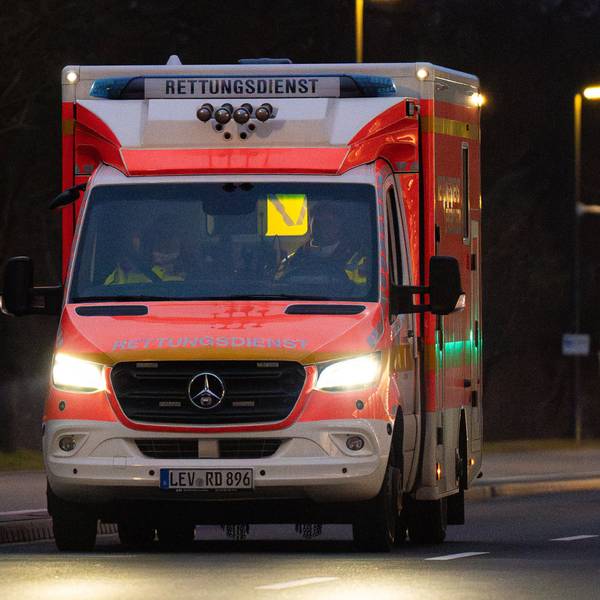 Ein Rettungswagen der Feuerwehr abends auf Einsatzfahrt in einer Leverkusener Straße