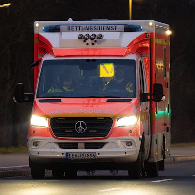 Ein Rettungswagen der Feuerwehr abends auf Einsatzfahrt in einer Leverkusener Straße