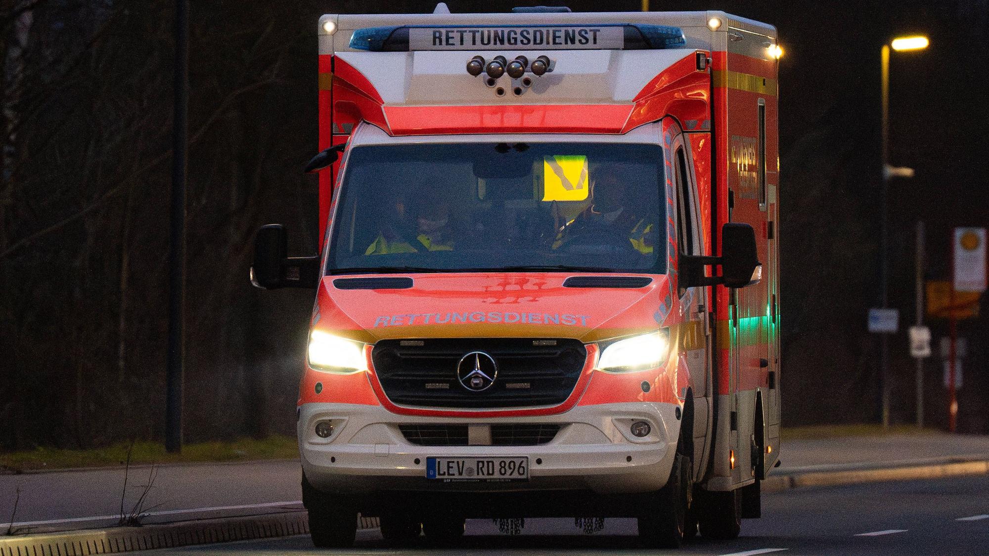 Ein Rettungswagen der Feuerwehr abends auf Einsatzfahrt in einer Leverkusener Straße