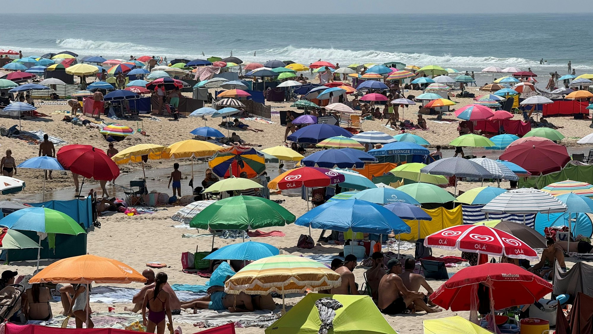 Ein Strand in Portugal: Bunte Farben und die Weite des Meeres im Kontrast.