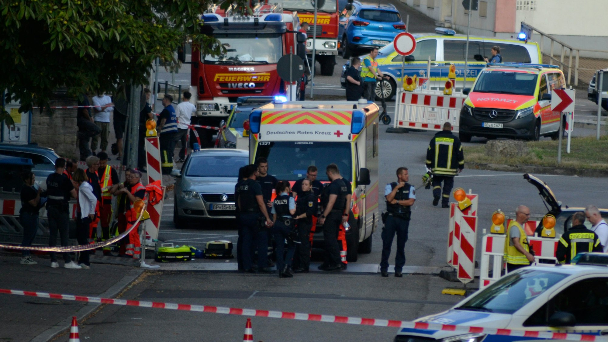 dpatopbilder - 21.08.2025, Saarland, Völklingen: Großeinsatz von Polizei und Rettungskräften in der Völklinger Innenstadt. Nach einem Raubüberfall auf eine Tankstelle im saarländischen Völklingen ist ein Polizist durch Schüsse getötet worden. Nach Angaben der Polizei hatte der mutmaßliche Täter dem Beamten bei einem Gerangel die Dienstwaffe entrissen und geschossen. Foto: Gianni Gattus/dpa +++ dpa-Bildfunk +++