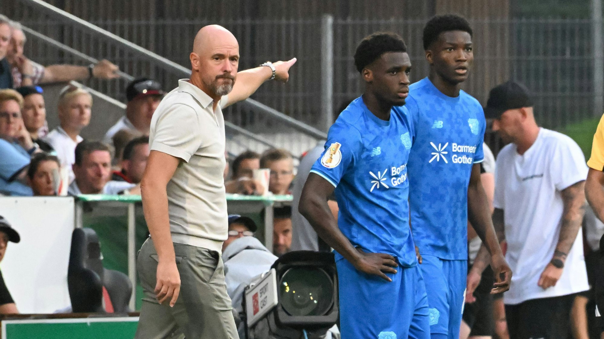 Leverkusens Coach Erik ten Hag im Pokalspiel in Großaspach mit den Zugängen Ernest Poku (l.) und Axel Tape.
