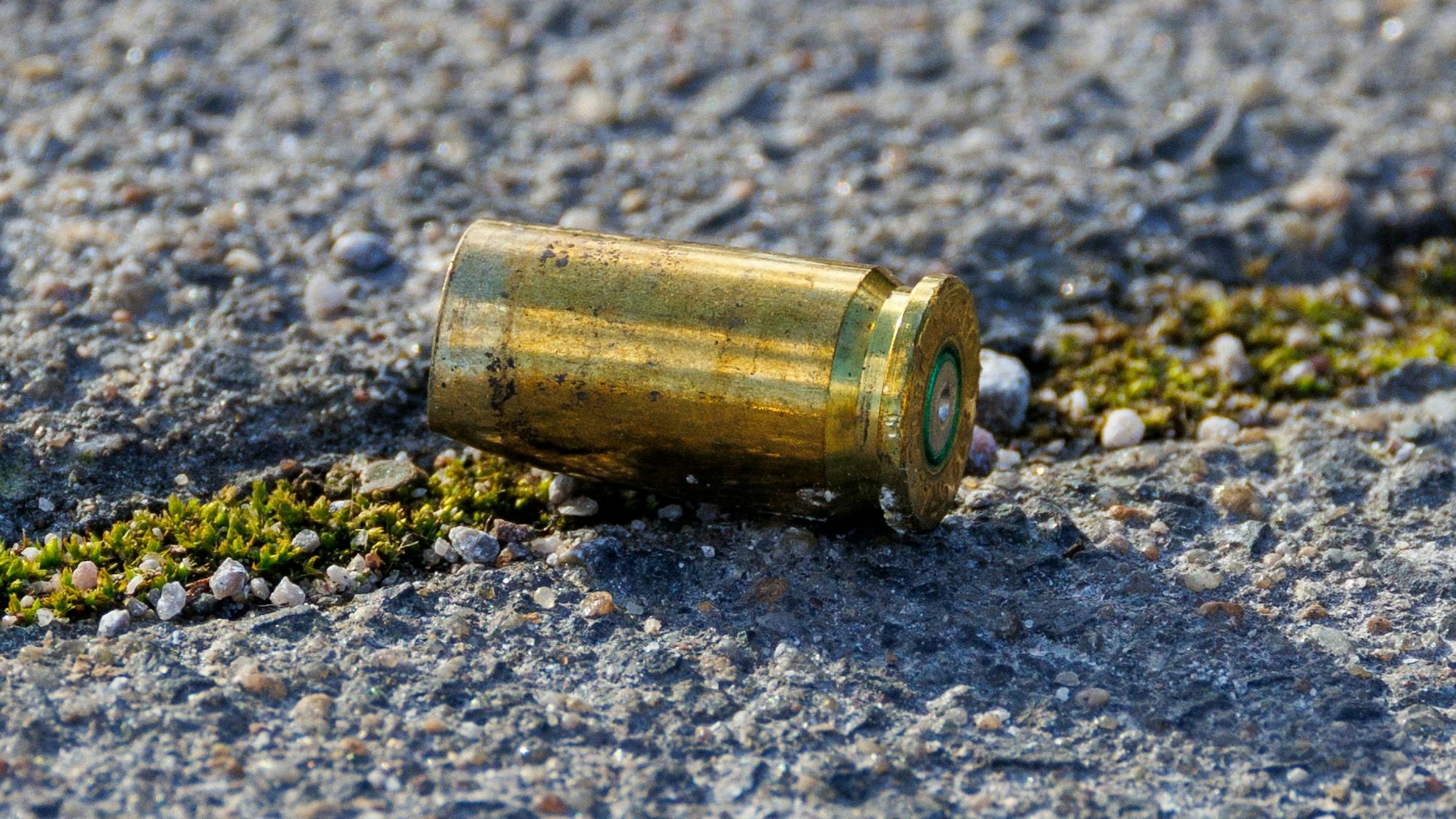 Das Bild zeigt eine Patronenhülse auf der Straße.