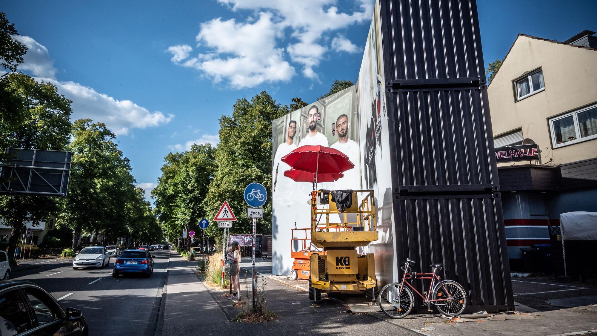 Eine temporäres Großbild an sechs Übersee-Containern auf einem privaten Parkplatz an der Bismarckstraße nahe Konrad-Adenauer-Platz muss wohl wieder abgebaut werden. Dort sollte für Trikots geworben werden. Bild: Ralf Krieger
