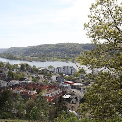 Ansicht eines Ortes mit dem Rhein im Hintergrund.