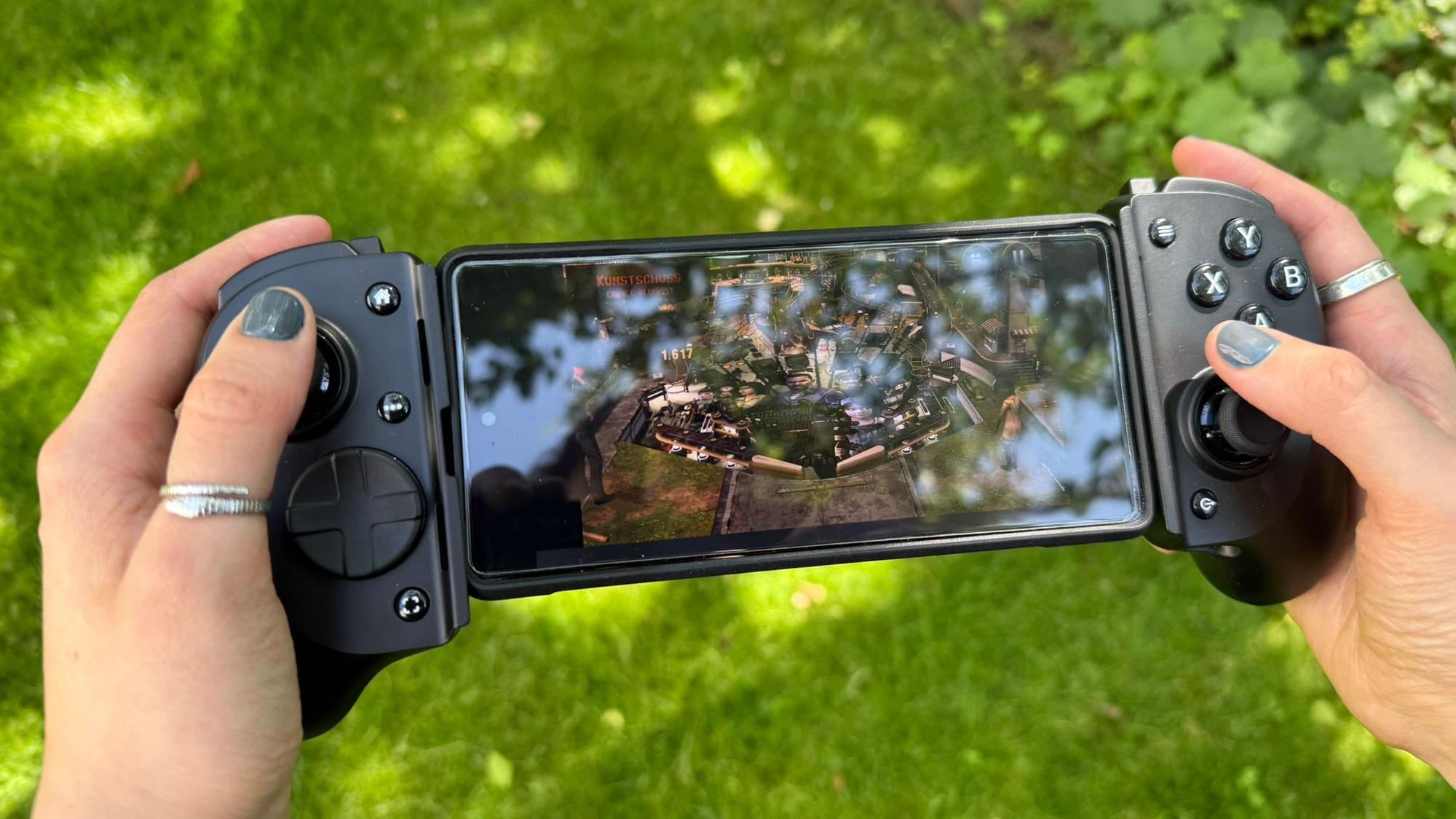 Eine Person hält eine mobile Gamoingkonsole in der Hand.