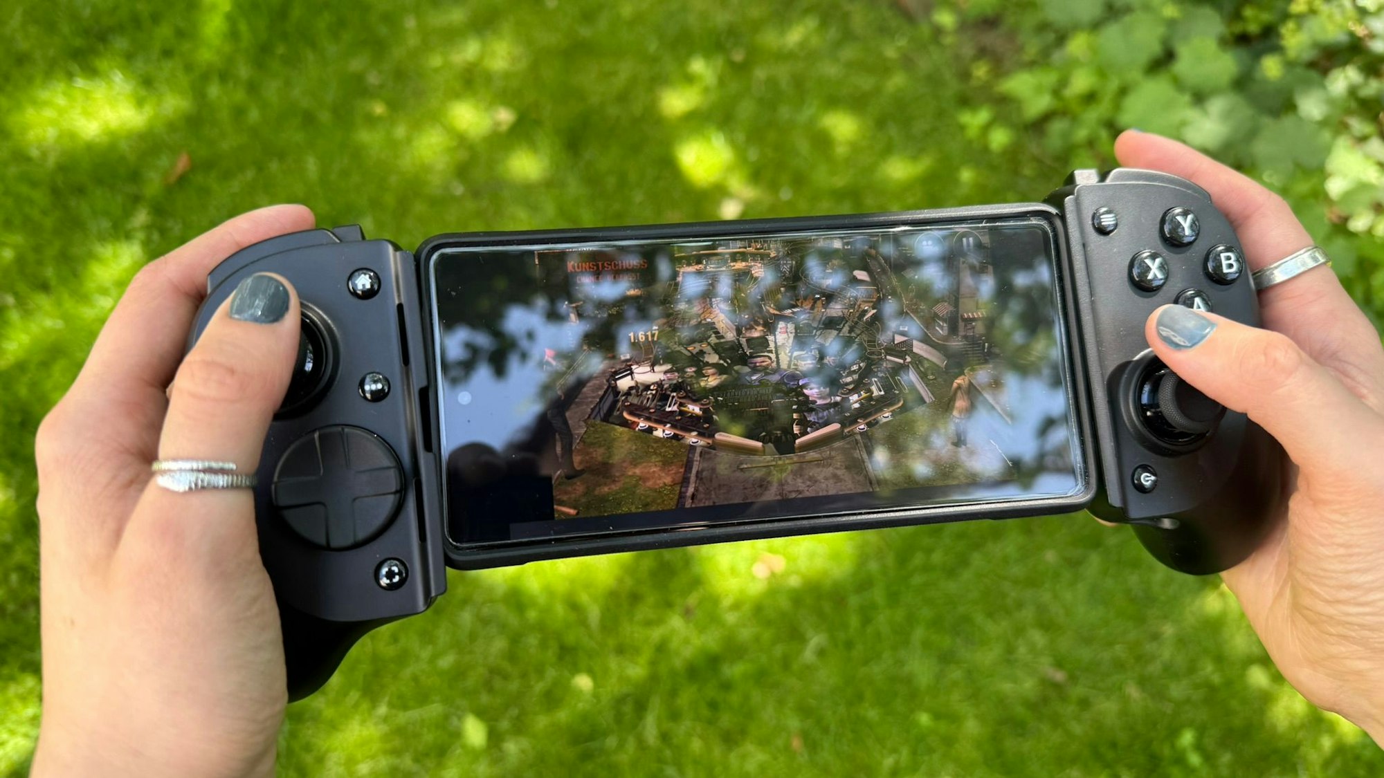 Eine Person hält eine mobile Gamoingkonsole in der Hand.