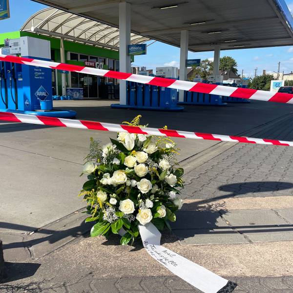 22.08.2025, Saarland, Völklingen: An der Tankstelle, an der nach einem Überfall ein Polizist getötet wurde, haben Mitarbeiter einen Kranz niedergelegt. Nach einem Raubüberfall auf die Tankstelle ist ein Polizist durch Schüsse getötet worden. Nach Angaben der Polizei hatte der mutmaßliche Täter dem Beamten bei einem Gerangel die Dienstwaffe entrissen und geschossen. Foto: Christian Schultz/dpa +++ dpa-Bildfunk +++