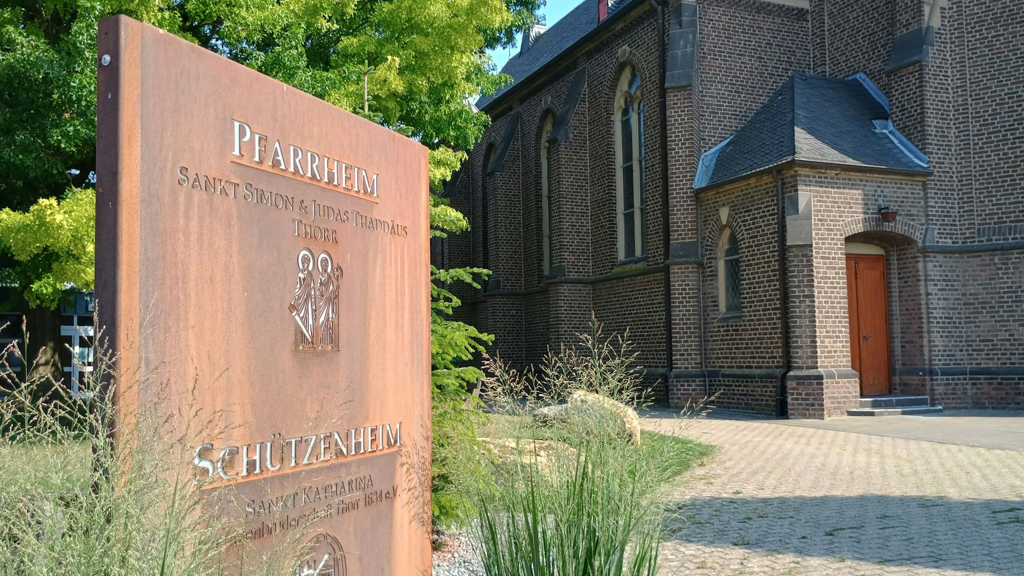 Das Bild zeigt eine Bronzetafel vor dem Pfarrheim Sankt Simon & Judas Thaddäus.