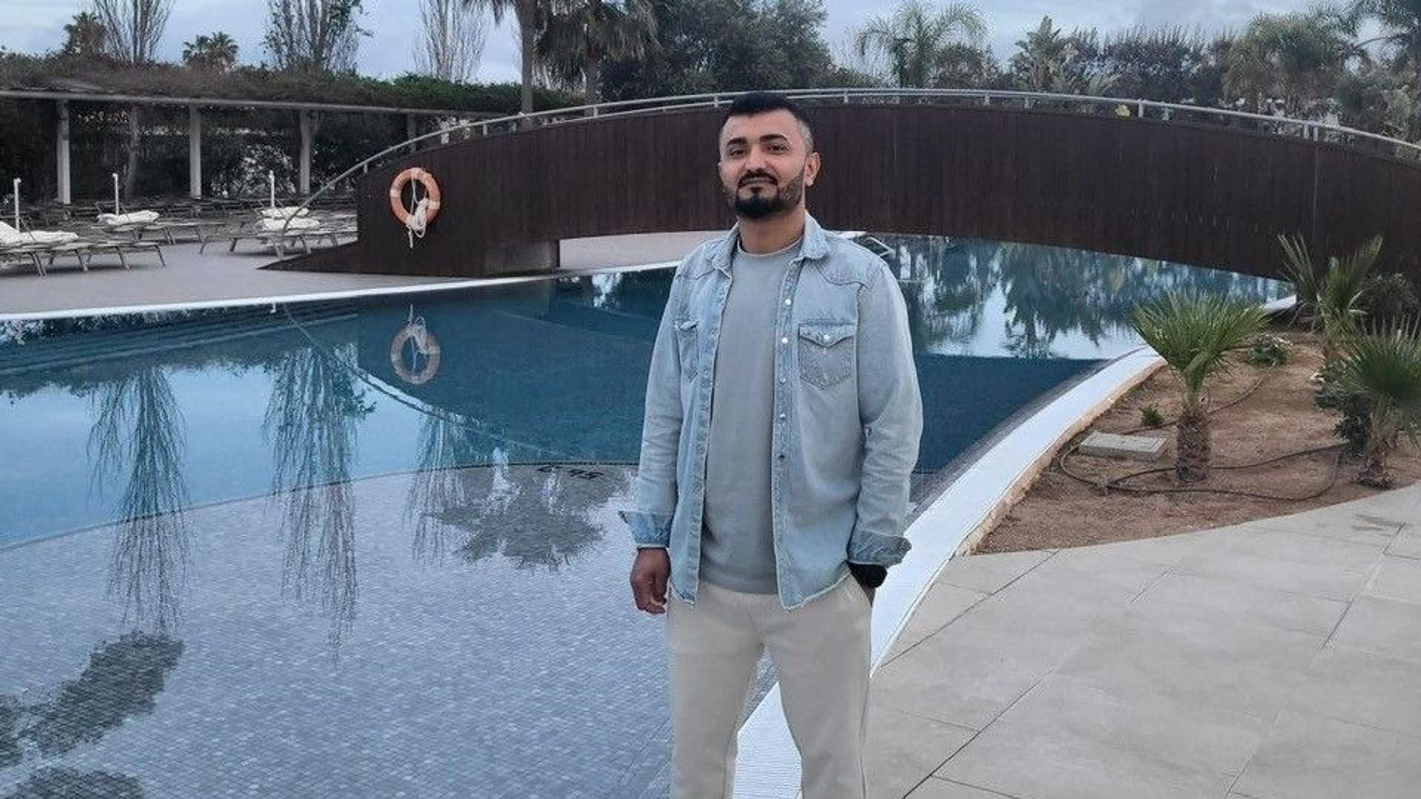 Nawid Hamidi steht an einem Hotelpool.