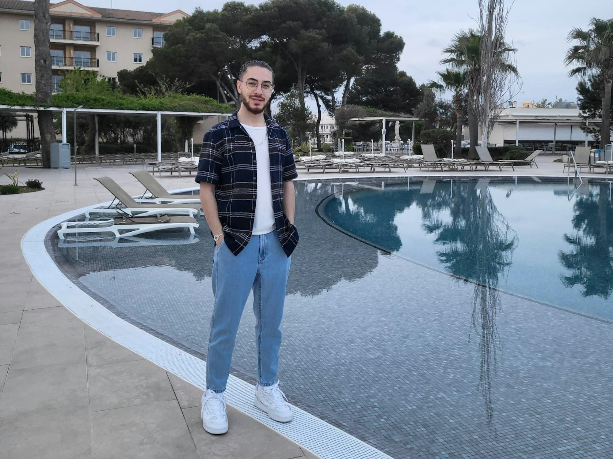 Wissam Abu Alneaj steht an einem Hotelpool.