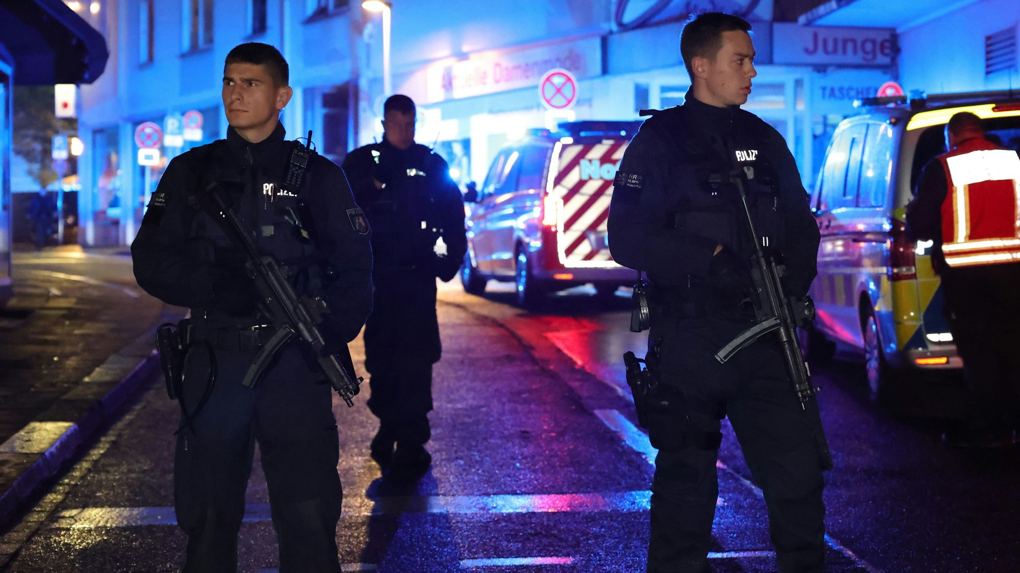 Polizei und Rettungswagen stehen in der Nacht des Anschlags in der Nähe des Fronhofs. Zwei junge Polizisten mit Maschinengewehr und ernstem Blick sind im Fokus des Bildes.