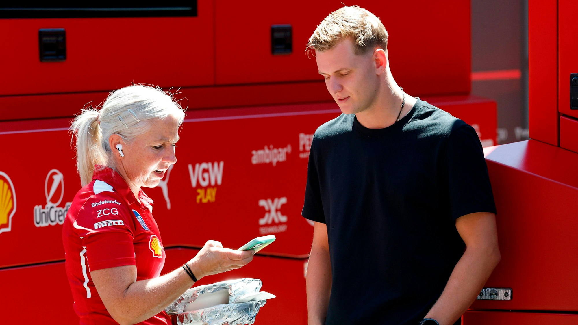 Mick Schumacher spricht mit einer Ferrari-Mitarbeiterin beim Großen Preis von Österreich.