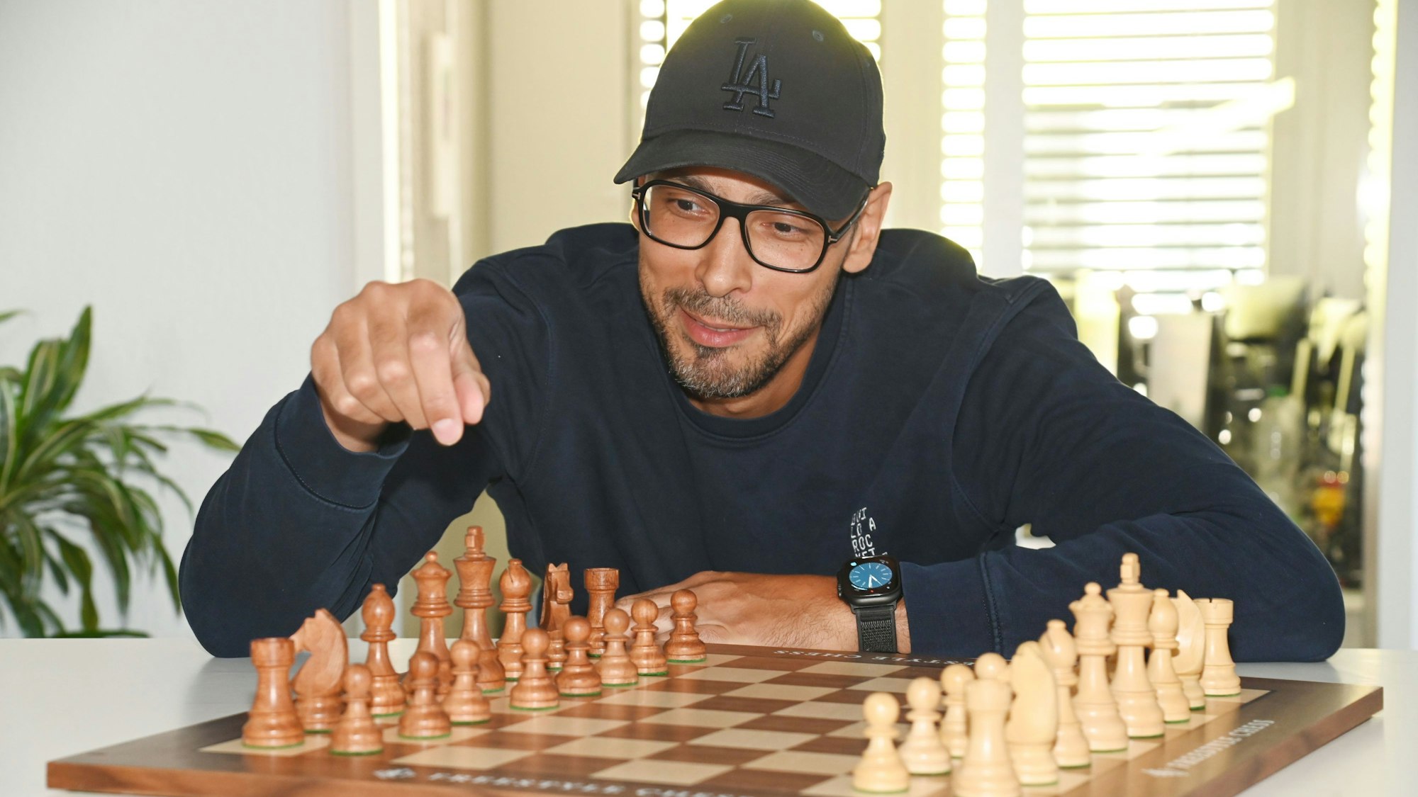 Alexander Albrecht bewegt Schachfiguren auf einem Schachbrett.